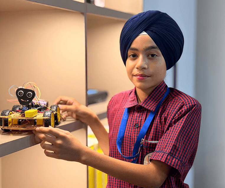 Young AIS students at robotics workbench